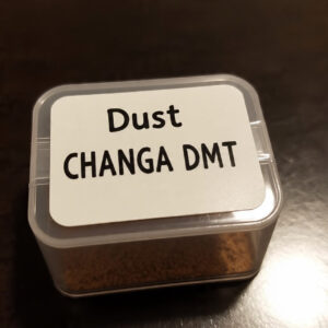 A plastic container labeled 'Dust Changa DMT' filled with a fine, powdery herbal blend used for vaporizing or smoking